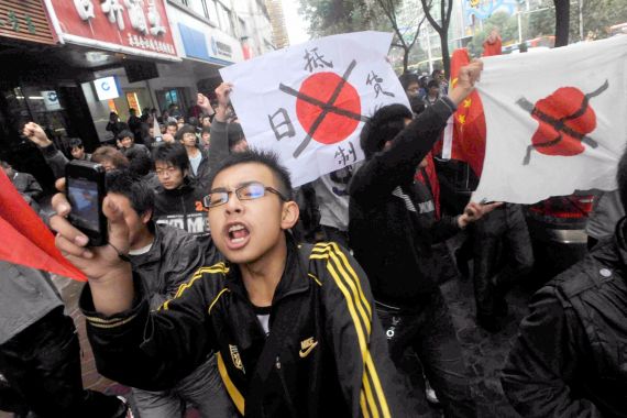 Protesters hold defaced Japanese flags during an anti-Japan demonstration in Lanzhou, Gansu province October 24, 2010. Chinese police on Sunday broke up protests against Japan in the northwestern city of Lanzhou over a territorial dispute that has stoked tensions between Asia's two biggest economies. REUTERS/Kyodo (CHINA - Tags: CIVIL UNREST POLITICS) FOR EDITORIAL USE ONLY. NOT FOR SALE FOR MARKETING OR ADVERTISING CAMPAIGNS. JAPAN OUT. NO COMMERCIAL OR EDITORIAL SALES IN JAPAN. THIS IMAGE HAS BEEN SUPPLIED BY A THIRD PARTY. IT IS DISTRIBUTED, EXACTLY AS RECEIVED BY REUTERS, AS A SERVICE TO CLIENTS
