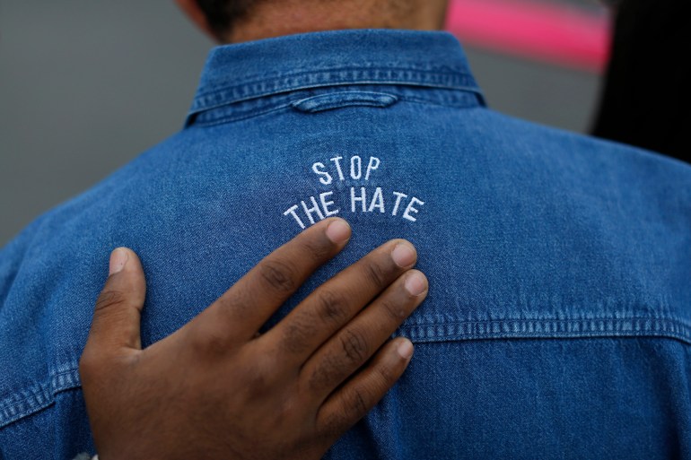 A protester is seen with the words 'Stop the hate' on his shirt