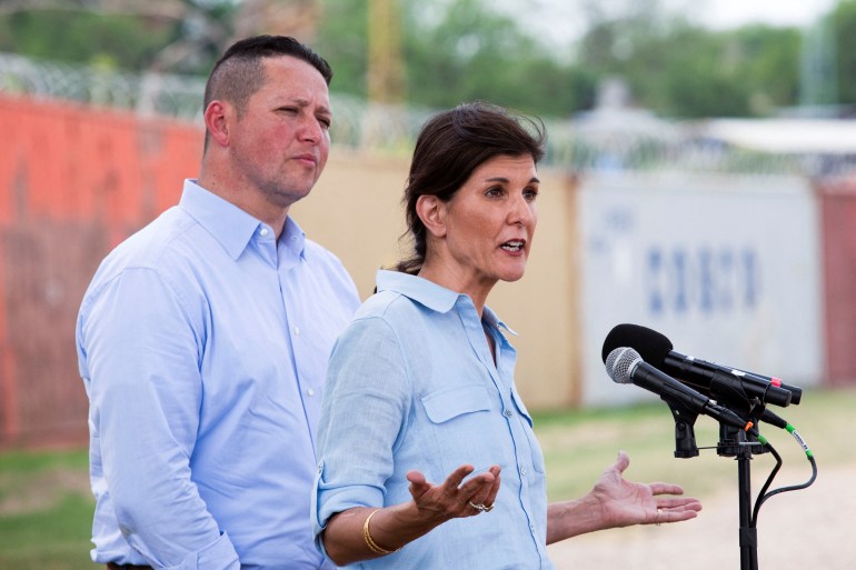 Tony Gonzales stands behind Nikki Haley, who speaks at an outdoor podium.