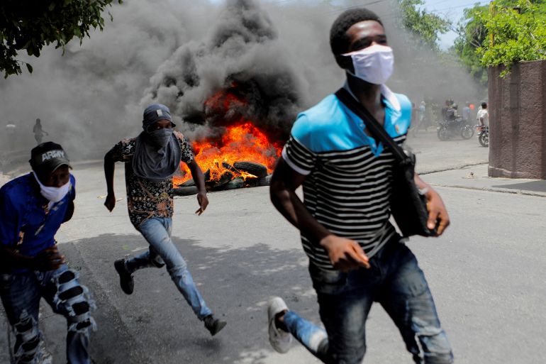 People run during a protest demanding an end to gang violence in Haiti