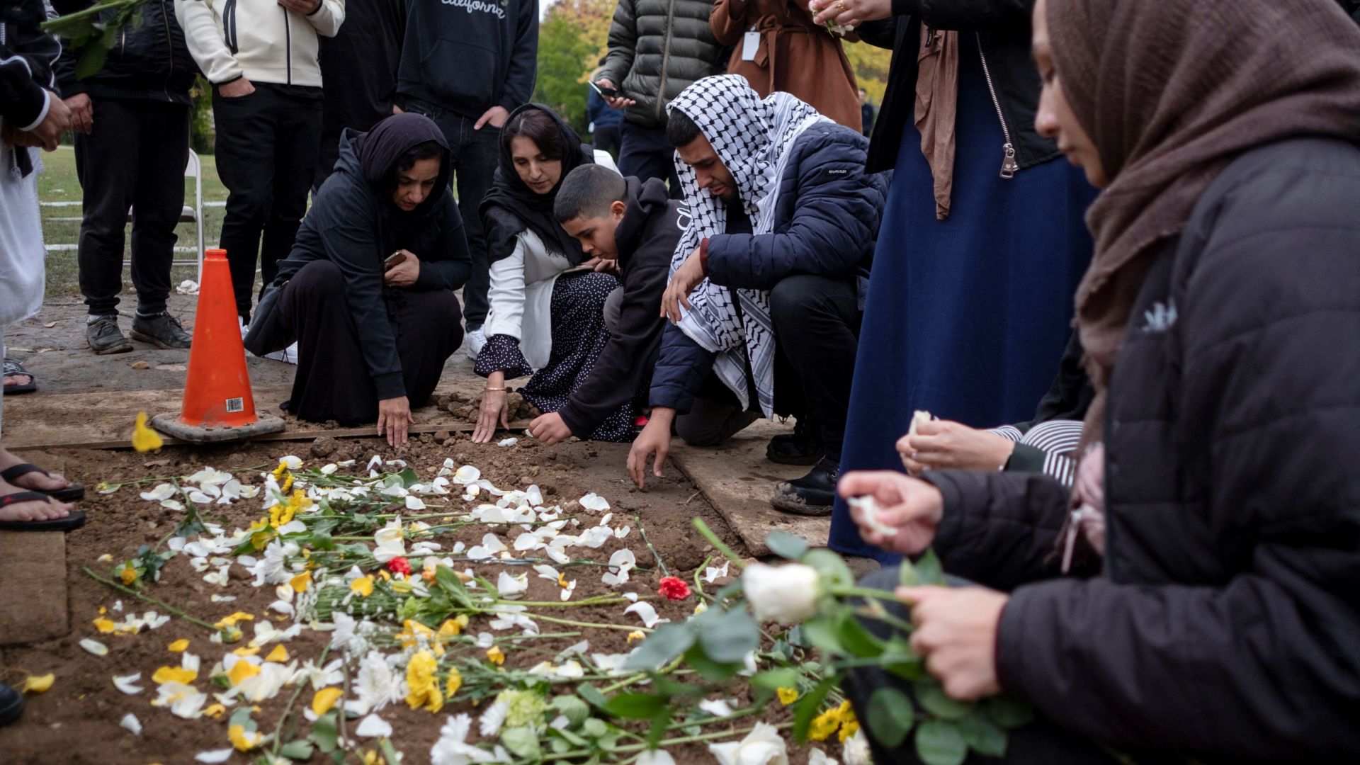 Mourners place flowers at the grave of Wadea Al-Fayoume, a six-year-old Palestinian American child, who was killed in a Chicago suburb