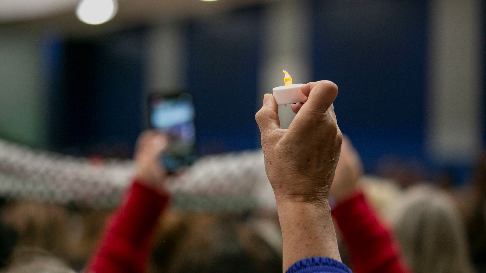 A mourner holds up a candle