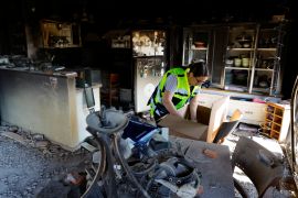 A representative from the Israeli Ministry of Defence works inside a damaged house following the October 7 deadly attack by Palestinian group Hamas, in Kibbutz Beeri, in southern Israel, November 16, 2023 [Alexander Ermochenko/Reuters]