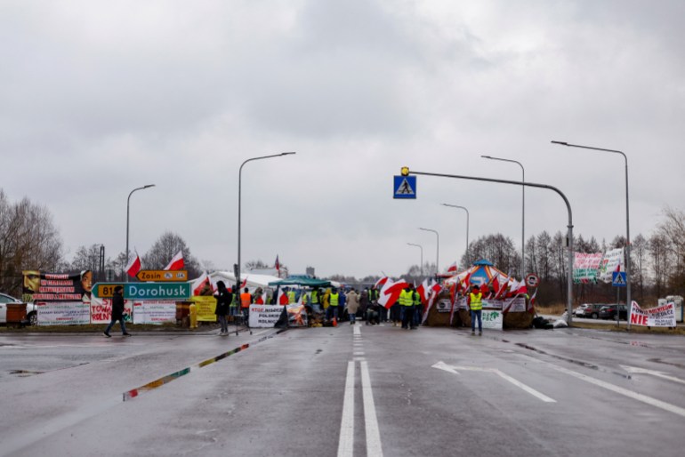 Polish farmers block the road to the border crossing during a protest in Okopy