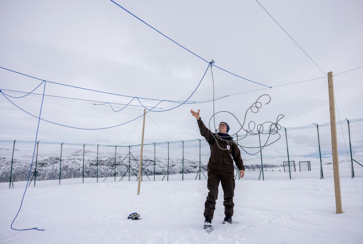 Conservation biologist Kristine R. Ulvund sets up ropes to protect foxes from eagle attacks, inside an enclosure at the Arctic Fox Captive Breeding Station run by Norwegian Institute for Nature Research (NINA) near Oppdal, Norway, March 22