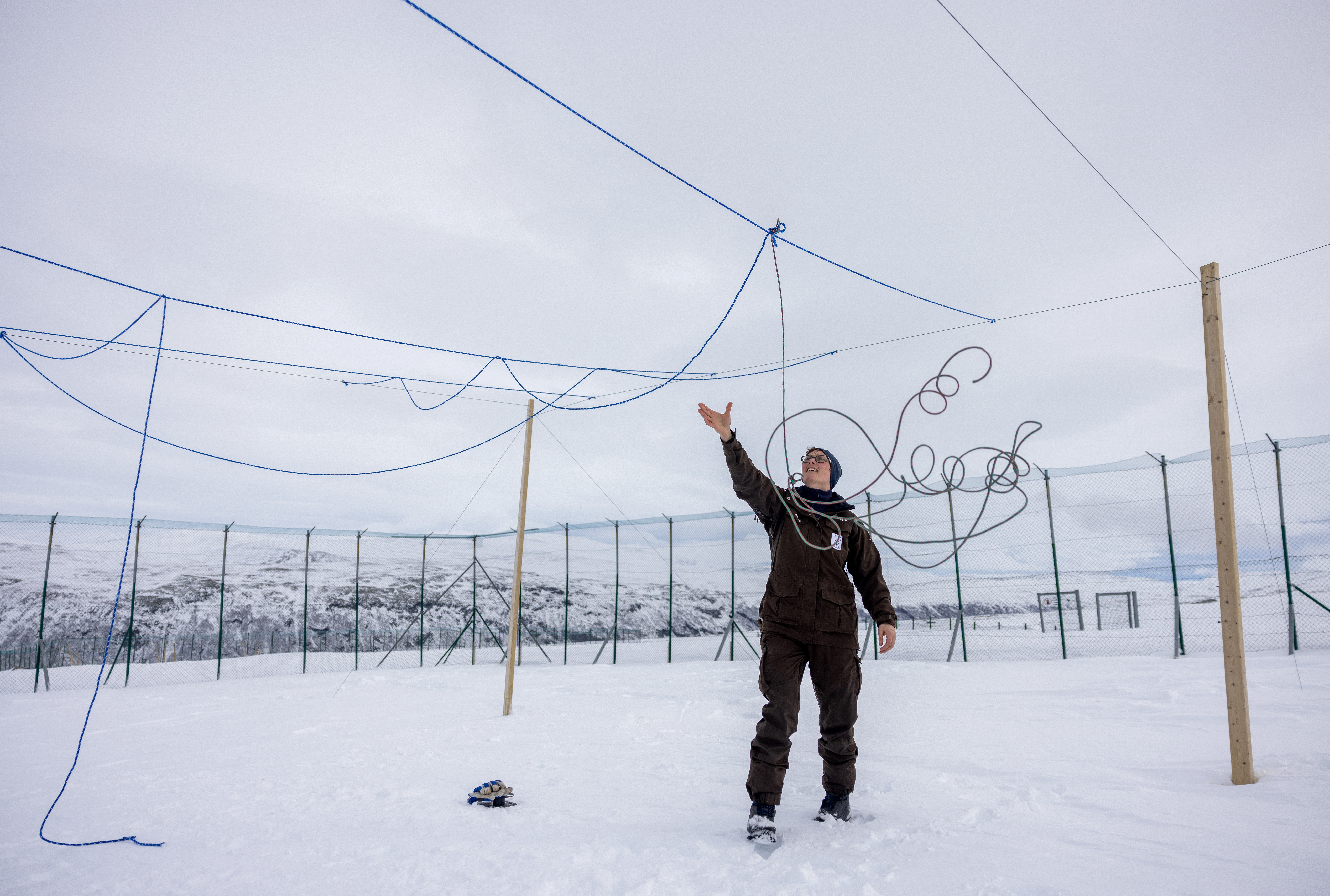 Conservation biologist Kristine R. Ulvund sets up ropes to protect foxes from eagle attacks, inside an enclosure at the Arctic Fox Captive Breeding Station run by Norwegian Institute for Nature Research (NINA) near Oppdal, Norway, March 22