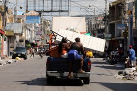 Haitians transport their belongings on a truck while fleeing their homes in Port-au-Prince