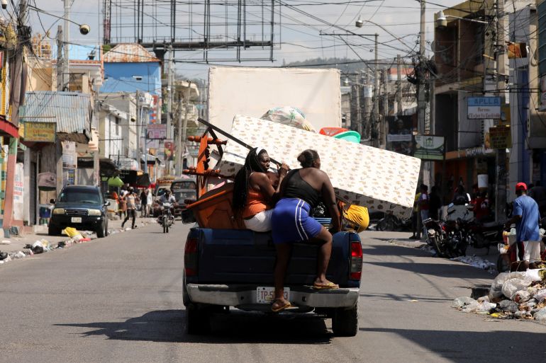 Haitians transport their belongings on a truck while fleeing their homes in Port-au-Prince