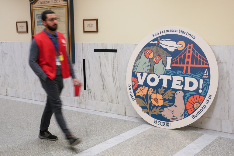 A person walks past a giant "I voted" circle in San Francisco's City Hall.