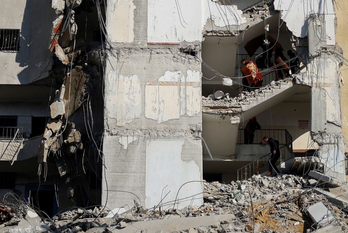 Palestinians carry belongings at the site of an Israeli air strike on a building in Rafah