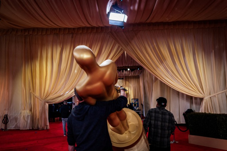 Workers carry an Oscar statue as preparations continue for the 96th Academy Awards in Los Angeles, California, U.S., March 9