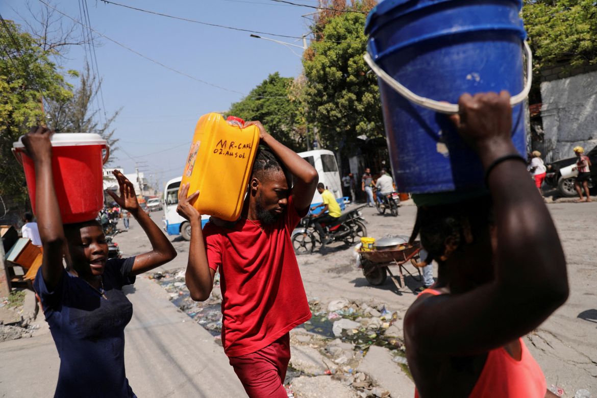 People carry water collected in buckets and containers