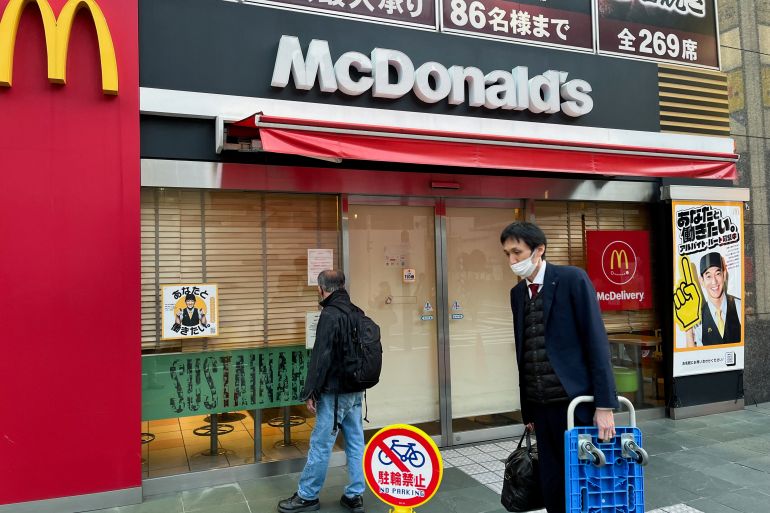 A man reads a notice in the window of a closed McDonald's restaurant as the company said it halted operations due to a system disruption, in Tokyo, Japan, on March 15, 2024