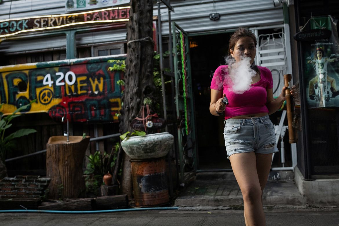 Doughnut smokes cannabis with a bong, outside a cannabis club called the Green Party in the outskirts of Bangkok, Thailand, October 7