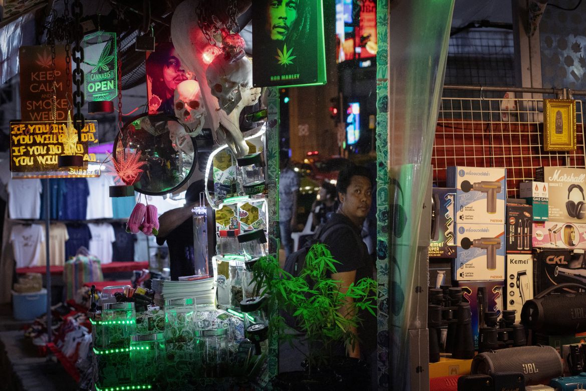 A man walks past a stand selling cannabis on the street in Bangkok, Thailand