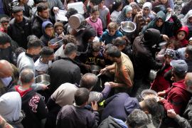 Palestinians gather to receive free food as Gaza residents face crisis levels of hunger, during the holy month of Ramadan, amid the ongoing conflict between Israel and Hamas, in Jabalia in the northern Gaza Strip