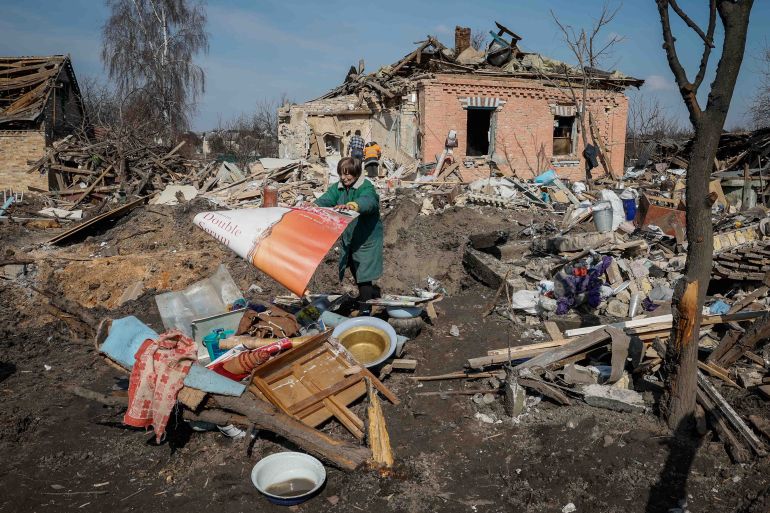 Halyna, a local resident, throws stuff near her house, destroyed during a Russian missile strike, amid Russia's attack on Ukraine, near Kyiv