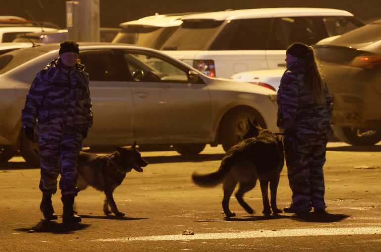 Russian law enforcement outside the Crocus City Hall. They have dogs with them.
