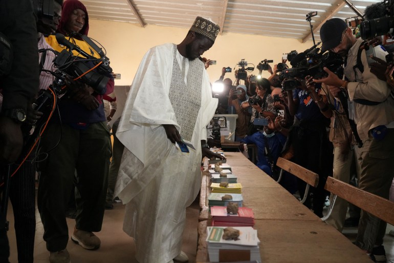 Presidential candidate Bassirou Diomaye Faye, who is backed by Senegalese opposition leader Ousmane Sonko, collects voting ballots at the polling station at Ndiaganiao in Mbour, Senegal March 24
