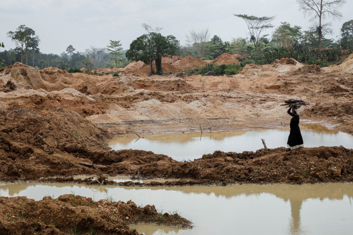 A farmer walks across a section of a cocoa plantation destroyed by illegal gold mining activities in the Samreboi community in the Western Region, Ghana, February 26