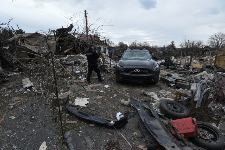 A police officer inspects a residential area heavily damaged during a Russian missile and drone strike
