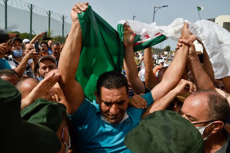 Karim Tabbou, one of the most prominent if not the best-known figure of "Hirak", is greeted upon his release from prison on July 2, 2020, outside the Kolea Prison near the city of Tipasa, 70km west of the capital Algiers. (Photo by RYAD KRAMDI / AFP)