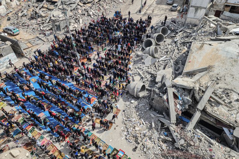 In this aerial view, Palestinians attend the Friday noon prayers in front of the ruins of the al-Faruq mosque, destroyed in Israeli strikes in Rafah in the southern Gaza Strip on March 1, 2024, amid continuing battles between Israel and the Palestinian militant group Hamas. (Photo by SAID KHATIB / AFP)