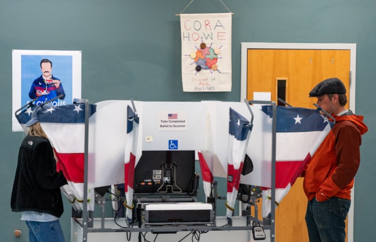 People voting in blue, white and red booths