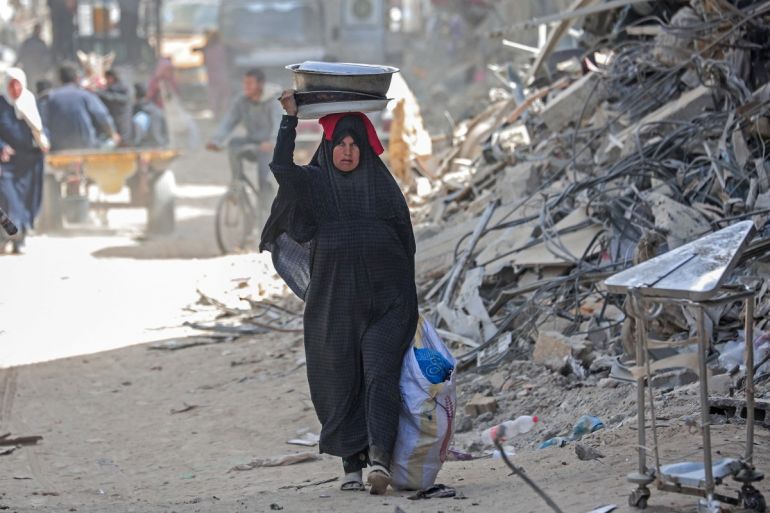 A displaced Palestinian woman carries her belongings in Khan Younis, March 6, 2024. [AFP)]