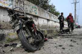 Security personnel examine the site of a blast in Peshawar