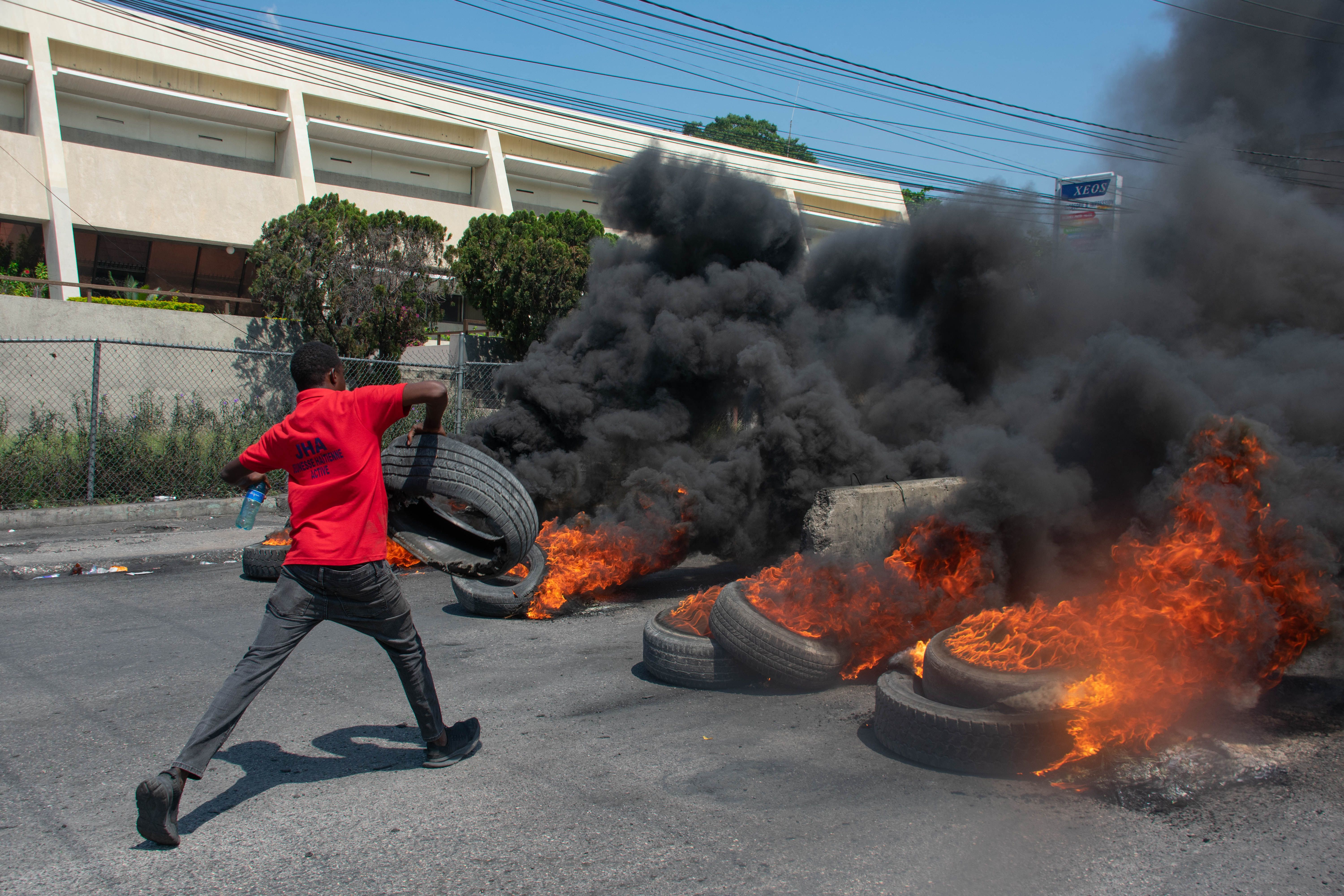 A protester burns tires during a demonstration following the resignation of its Prime Minister Ariel Henry, in Port-au-Prince, Haiti, on March 12