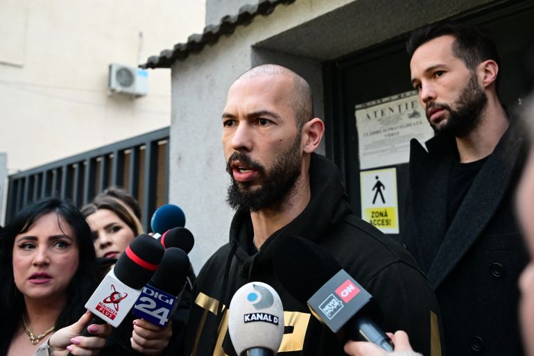 British-US former professional kickboxer and controversial influencer Andrew Tate (C) and his brother Tristan Tate (R) speak to journalists after having been released from detention in Bucharest, Romania