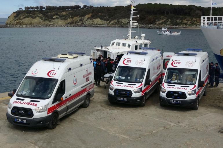 ambulances parked by a coast guard boat