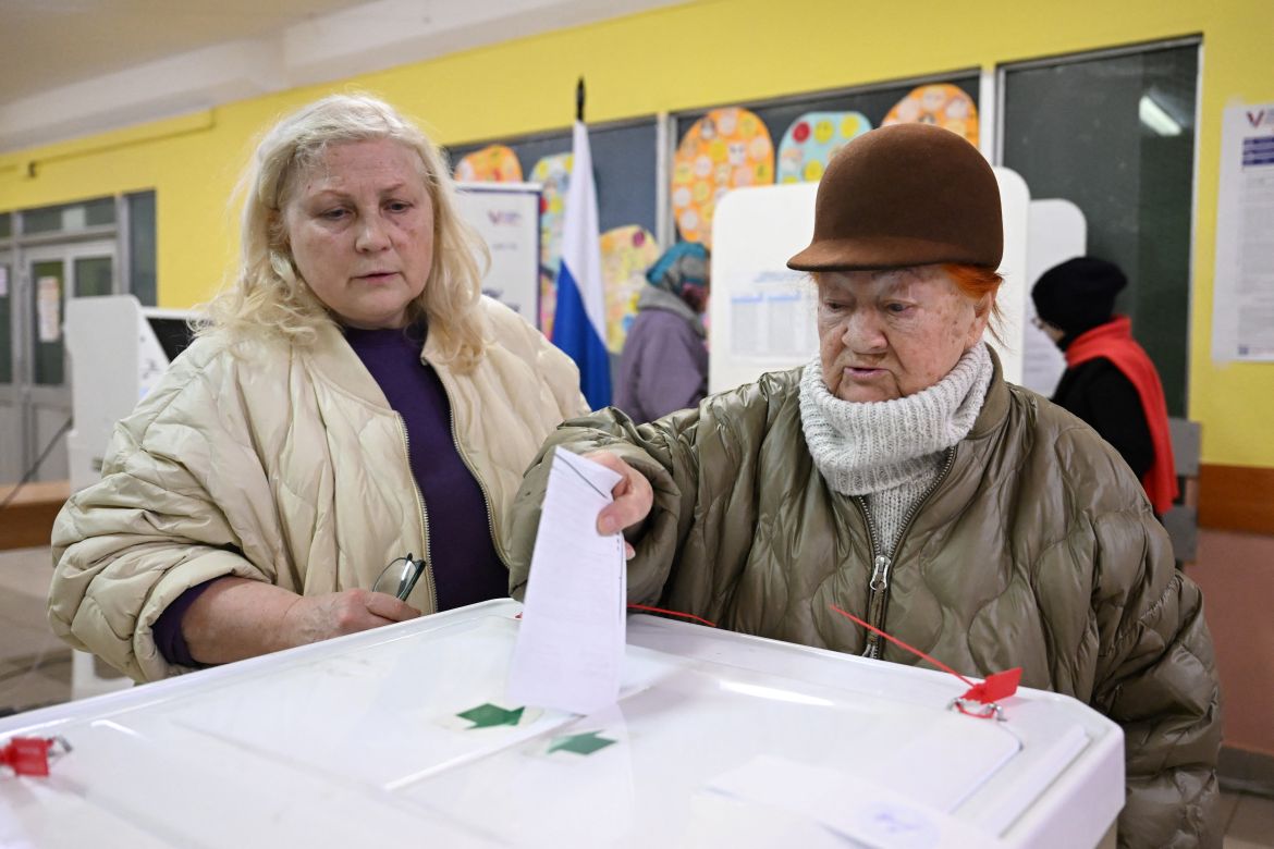 A woman casts her ballot during Russia's presidential election at a polling station in Moscow on March 17, 2024. - Russian opposition has called on people to head to the polls on March 17