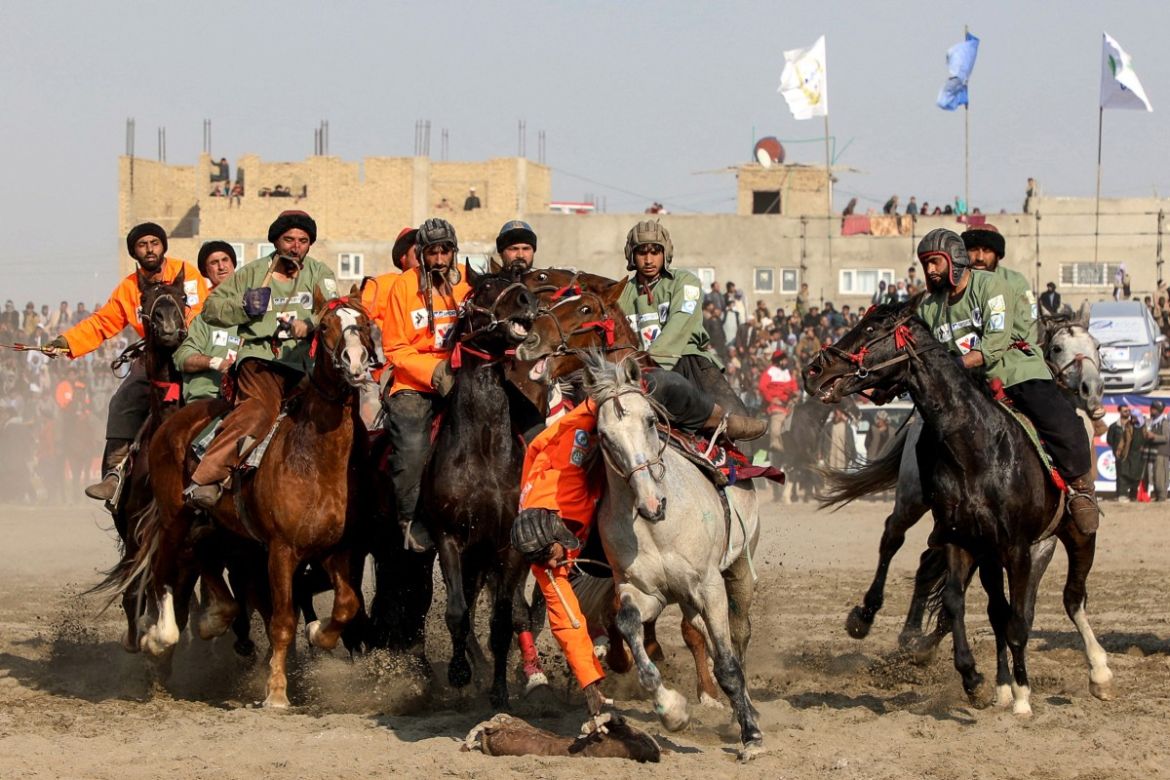 This photograph taken on March 8, 2024 shows Afghan riders of the Yama Petroleum (orange) and Baghlan teams competing at the Buzkashi league tournament final in Mazar-i- Sharif