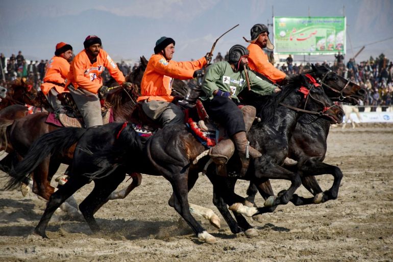 This photograph taken on March 8, 2024 shows Afghan riders of the Yama Petroleum (orange) and Baghlan teams competing at the Buzkashi league tournament final in Mazar-i- Sharif
