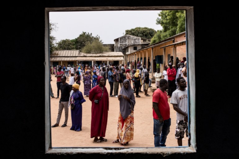 Voters wait in line to cast their votes outside a polling station in Ziguinchor