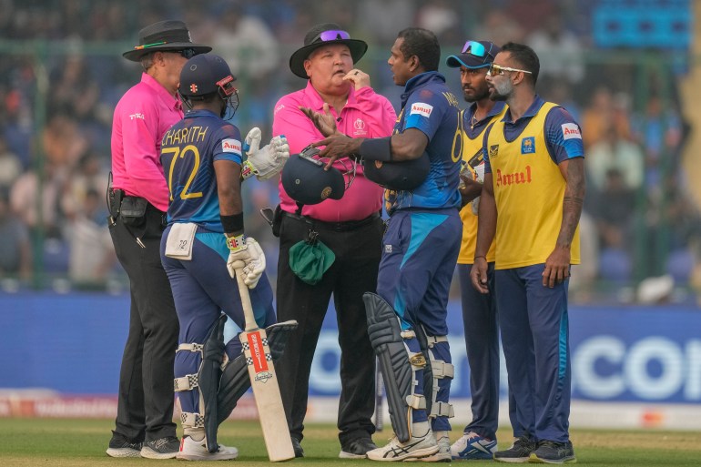 Sri Lanka's Angelo Mathews, third right, talks to umpires after he was declared timed out during the ICC Men's Cricket World Cup match between Bangladesh and Sri Lanka in New Delhi, India, Monday, Nov. 6, 2023. Mathews who wasn’t ready to face his first ball within the stipulated two minutes became the first batter to be timed out in international cricket as the strap of his helmet appeared to be broken and he called for a replacement helmet. (AP Photo/Manish Swarup)