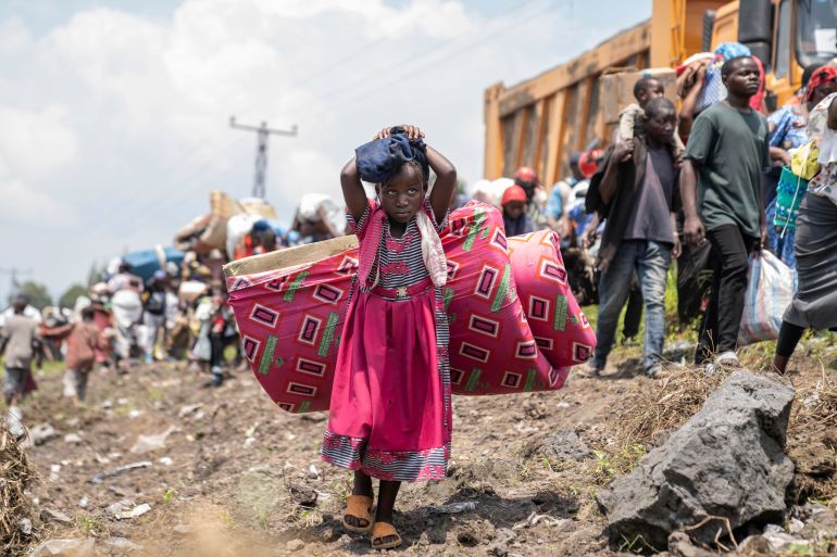 Thousands who are fleeing the ongoing conflict between government forces and M-23 rebels reach the entrance the Democratic Republic of Congo eastern city of Goma Wednesday, Feb. 7, 2024. (AP Photo/Moses Sawasawa)