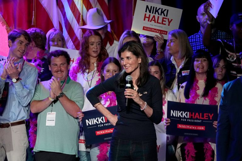 Nikki Haley speaks into a mic with her hands on her hips.