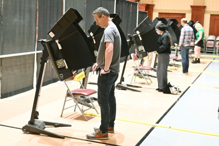 People voting in black booths