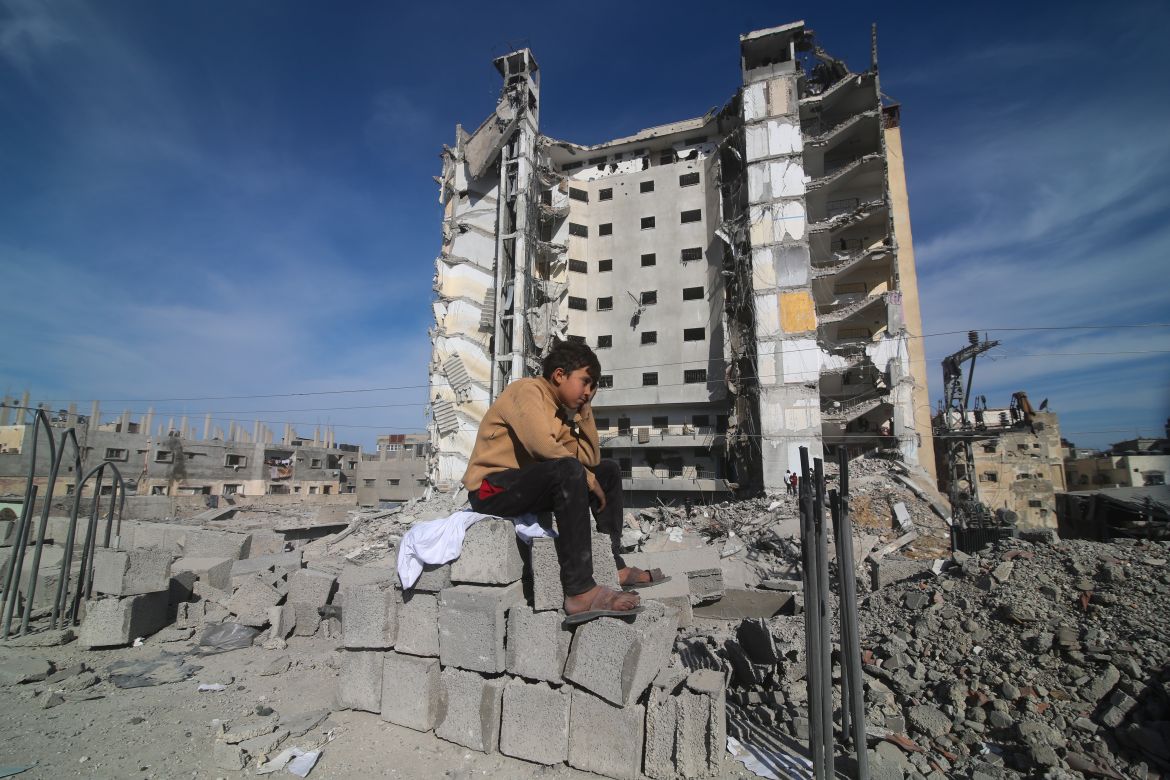 A Palestinian boy sits outside a residential building destroyed in an Israeli strike in Rafah, Gaza Strip, Saturday, March 9