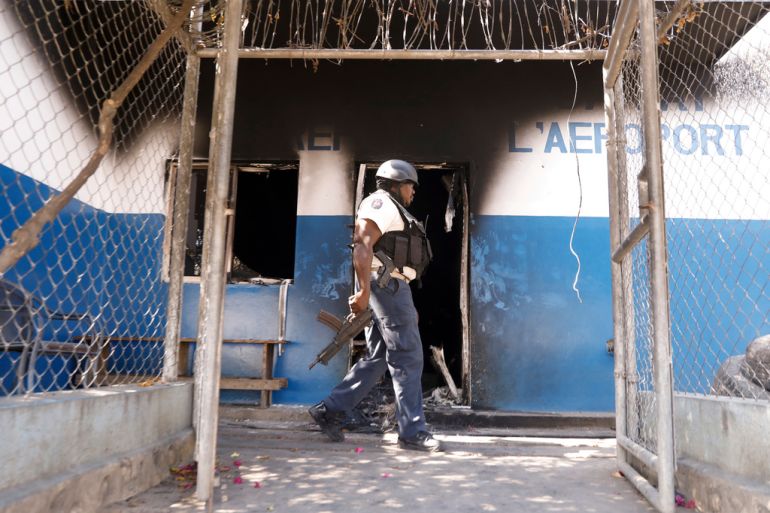 A police officer walks past a torched police station