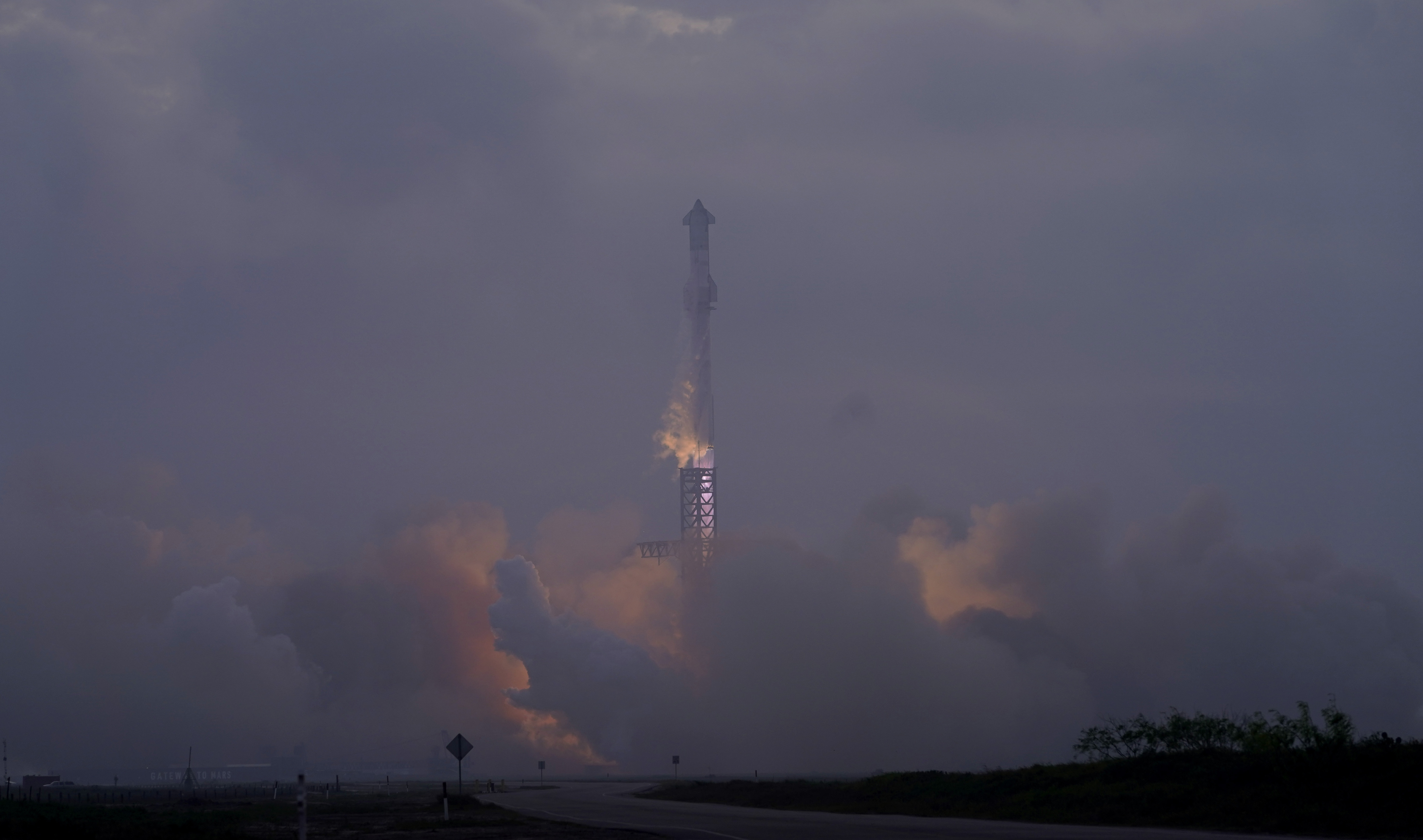 SpaceX's mega rocket Starship launches at dawn in the haze on it's third test flight from Starbase in Boca Chica, Texas