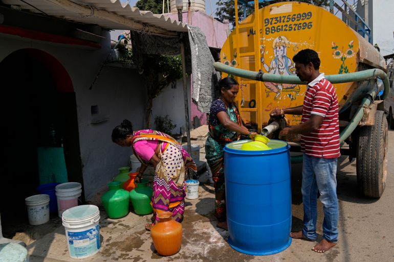 Residents of Ambedkar Nagar, a low-income settlement in the shadows of global software companies in Whitefield neighborhood, collect potable water from a private tanker in Bengaluru, India