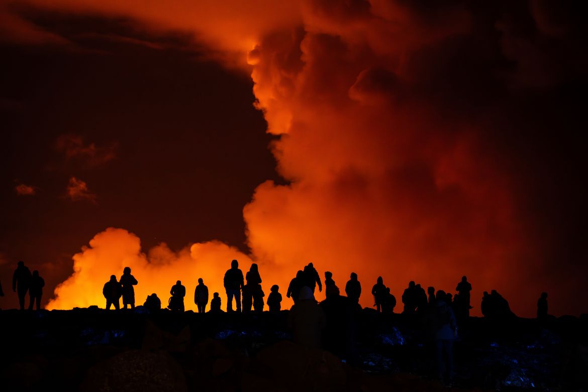 Spectators watch plumes of smoke from volcanic activity between Hagafell and Stóri-Skógfell
