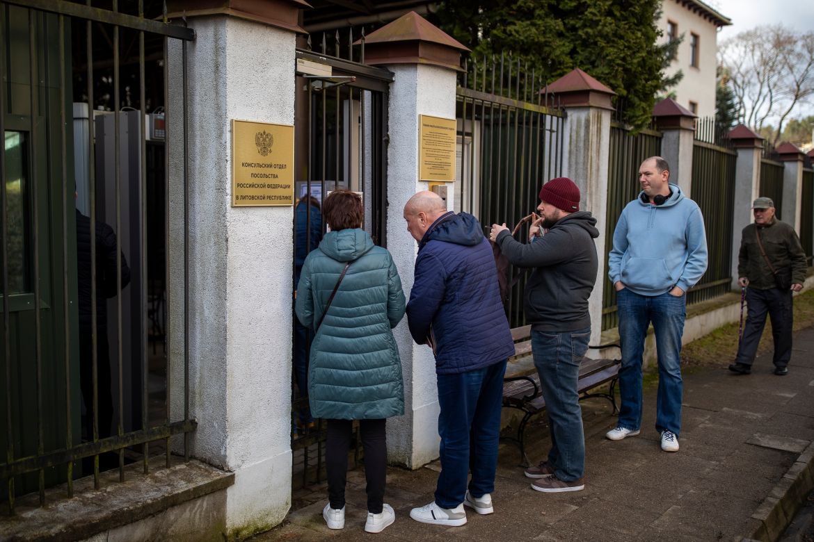 People stand in line outside a polling station during a presidential election at the Russian embassy in Vilnius