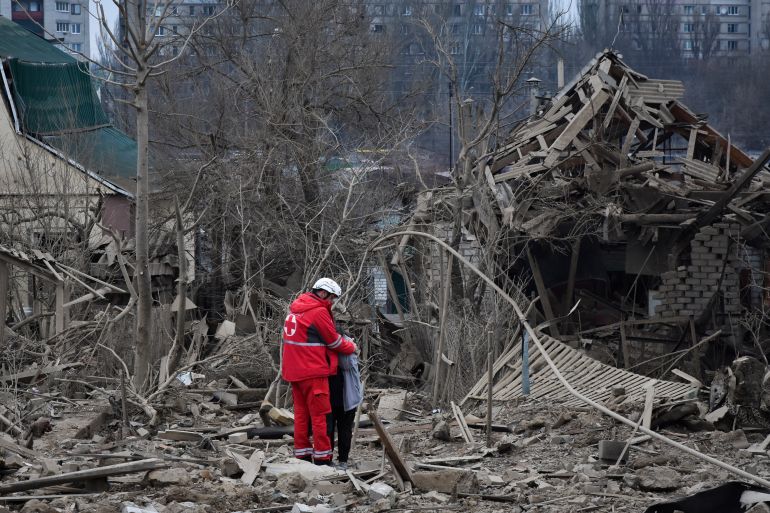 A medical worker comforts a woman at the site of Russia's air attack, in Zaporizhzhia, Ukraine