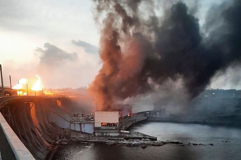 smoke and fire rise over the Dnipro hydroelectric power plant after it was hit by Russian missiles