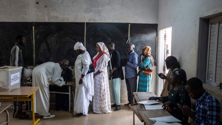 People wait to cast their votes inside a polling station during the presidential elections, in Dakar